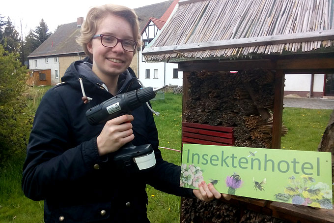 Lucie Gitschel bringt das neue Schild für das Insektenhotel in der NABU-Naturschutzstation Teichhaus Eschefeld an - Foto: Janine Kirchner