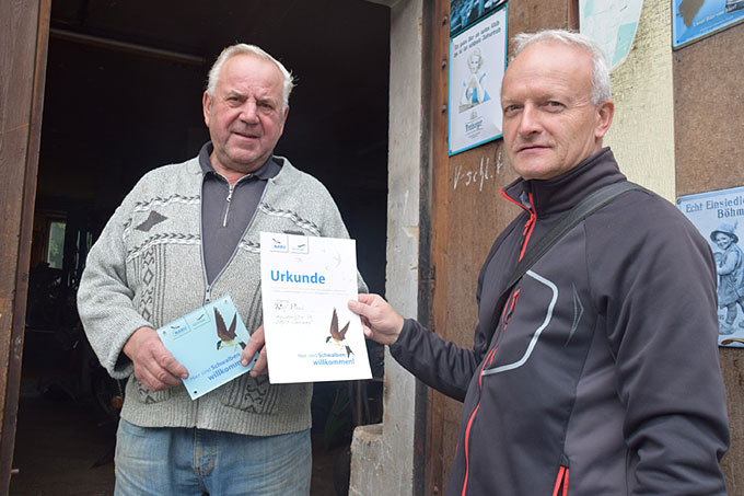 Rolf Pauli (links) erhielt von Lutz Röder (NABU Erzgebirge) Plakette und Urkunde „Hier sind Schwalben willkommen“ - Foto: Hans-Jürgen Görner